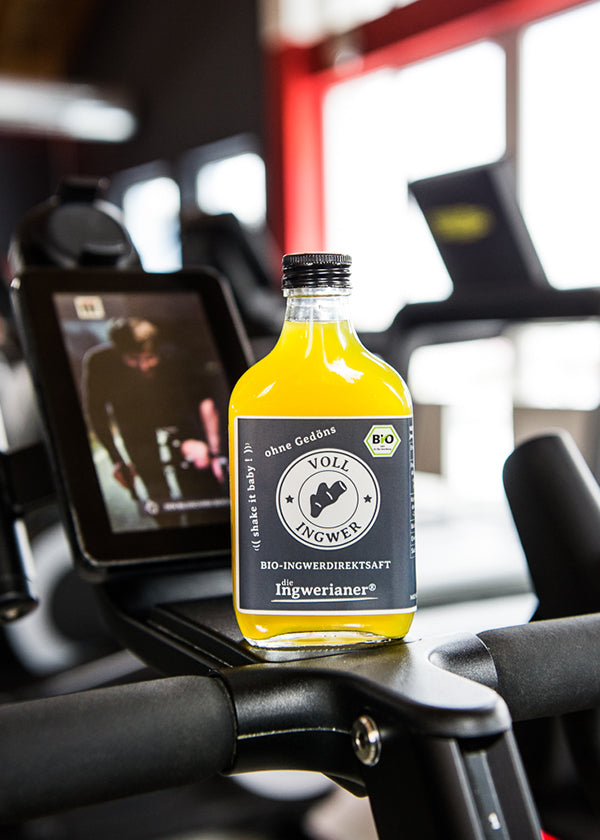Eine Flasche Ingwerianer® - Bio Ingwersaft, steht auf einem Sportgerät in einem Fitness-Studio