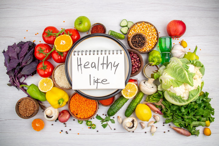 Das Bild zeigt verschiedene Gemüsesorten. In der Mitte ist ein Block mit dem Schriftzug "Healthy Life"